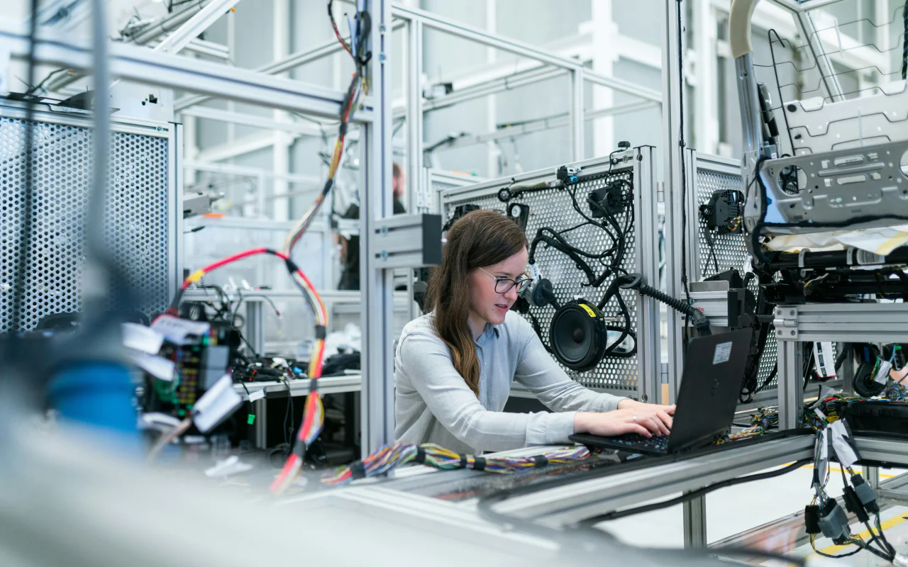 An engineer works at a laptop beside a test rig